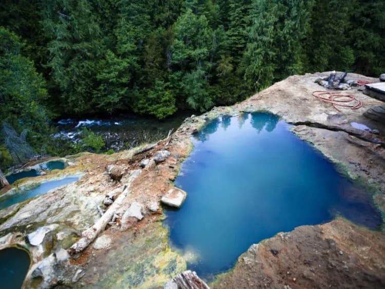 Mineral-encrusted terraced pools at Umpqua Hot Springs perched on a hillside above the North Umpqua River in Oregon old-growth forest