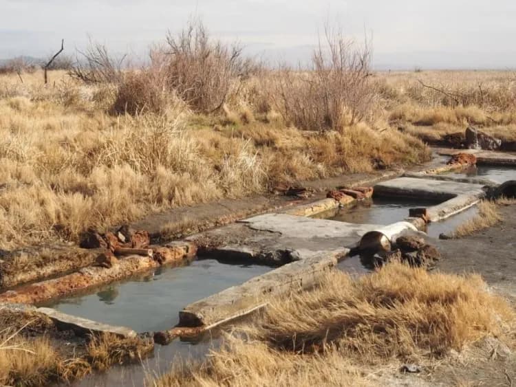 Geothermal pools at Baker Hot Springs near Delta Utah with volcanic cinder cones and colorful mineral deposits in desert setting